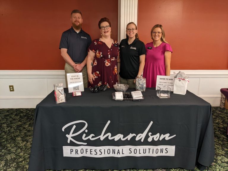 RPS team members at a promotional event standing behind decorated promotional table, Fort Gordon 2021